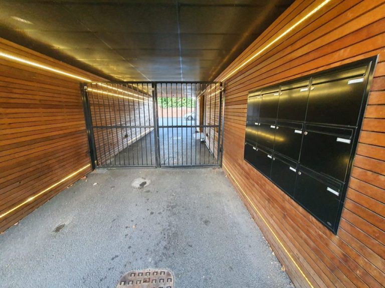 Communal metal access gate at the end of an entrance passage