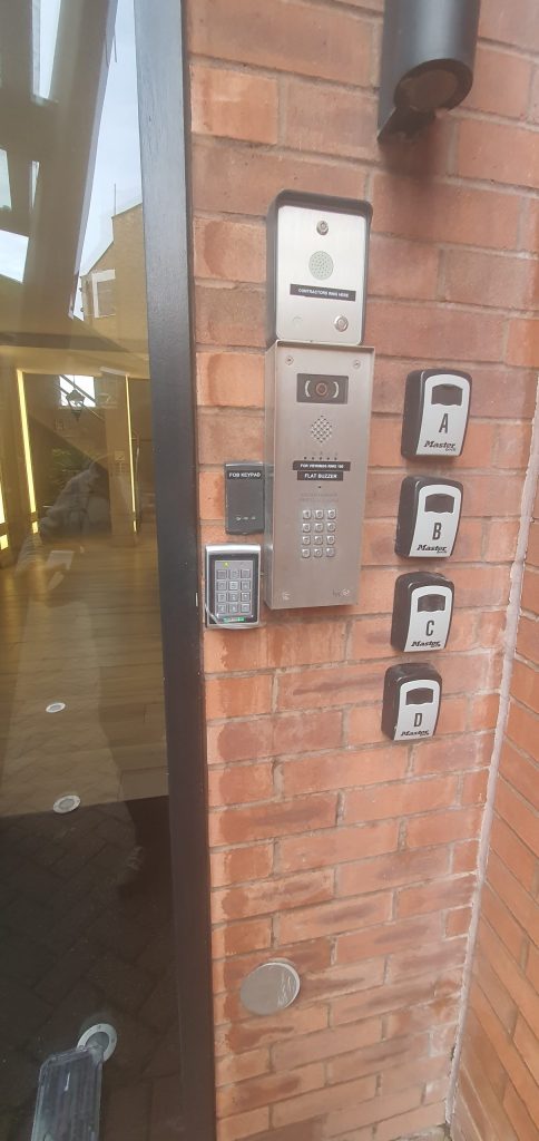 Intercom and keypad access control equipment beside a communal entrance