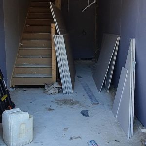 Unfinished entrance with internal stairs and building materials