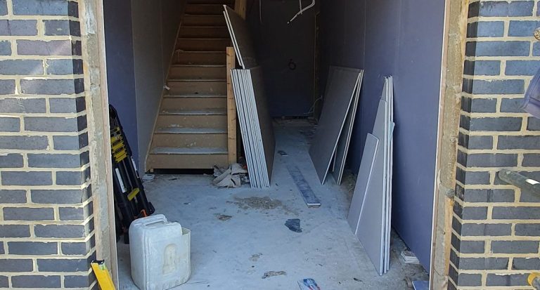 Unfinished entrance with internal stairs and building materials