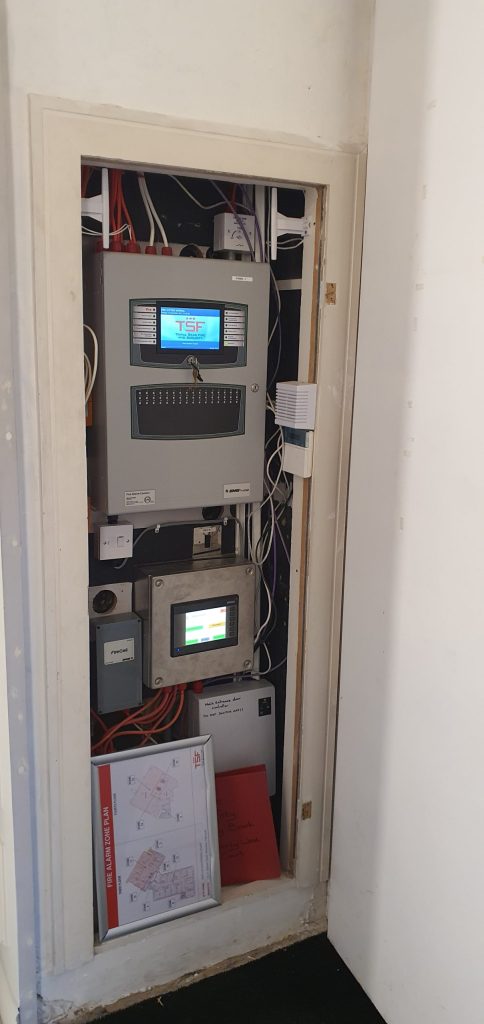 Fire alarm control equipment in a building service cabinet