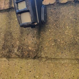Black site CCTV camera unit mounted on an exterior block wall