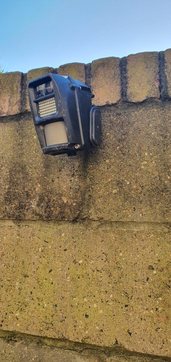 Black site CCTV camera unit mounted on an exterior block wall